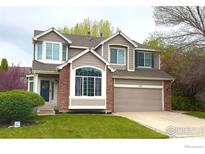 Charming two-story home with well-maintained lawn and attached two-car garage at 1611 Red Mountain Dr, Longmont, CO 80504