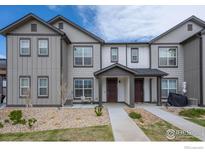 Charming townhome featuring gray siding, rock landscaping, and a welcoming covered entryway at 192 Ambrose St, Erie, CO 80516