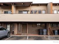 Charming townhouse exterior with brick accents and wood siding, complemented by neat landscaping and assigned parking at 1937 Meadow Dr # A7, Longmont, CO 80501