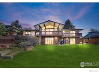 Expansive backyard featuring a lush lawn, covered patio, and inviting outdoor space for entertaining at 2490 Vassar Dr, Boulder, CO 80305