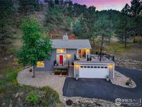 Charming home featuring a red door, two-car garage, and an elevated deck with mountain views at 2700 Crestridge Ct, Boulder, CO 80302