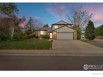 Charming two-story home featuring a well-maintained lawn and a two-car garage at sunset at 5151 S Quintero St, Centennial, CO 80015
