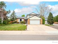 Charming two-story home featuring a well-maintained lawn, brick accents, and an attached two-car garage at 5151 S Quintero St, Centennial, CO 80015
