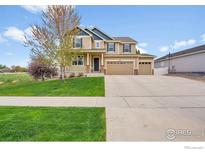 Beautiful two-story home featuring a manicured lawn, a three-car garage, and charming curb appeal at 5478 Teton Dr, Longmont, CO 80504