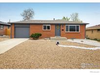 Charming single-story brick home with a gray roof and low-maintenance gravel landscaping at 740 Lotus Way, Broomfield, CO 80020