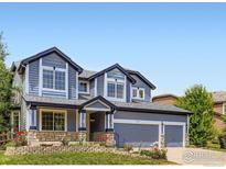 Charming two-story blue home with a well-manicured lawn and a two car garage in a great neighborhood at 910 Pope Dr, Erie, CO 80516