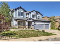 Charming two-story home featuring a well-maintained lawn and inviting curb appeal at 910 Pope Dr, Erie, CO 80516
