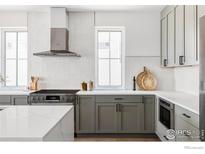 Modern kitchen with gray cabinetry, stainless steel appliances, and bright white countertops at 914 Eldorado Ln, Louisville, CO 80027