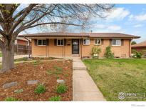 Charming brick home with a well-maintained front yard and mature tree, offering curb appeal at 9261 Julian Way, Westminster, CO 80031