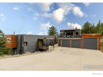 Contemporary home featuring a three-car garage, balcony, and architectural design at 1440 Reed Ranch Rd, Boulder, CO 80302
