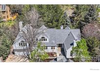 Stunning exterior view of home, featuring mature trees and a well-manicured landscape, creating a serene and private setting at 2672 Winding Trail Dr, Boulder, CO 80304