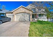 Charming home features a stone facade, well-maintained lawn, and a cozy front porch, complete with a three car garage at 8574 W 94Th Ave, Westminster, CO 80021