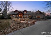 Stunning single-Gathering home showcasing a meticulously landscaped front yard with a stone walkway at 8912 Little Raven Trl, Niwot, CO 80503