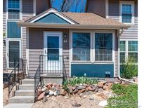 Charming townhome entrance with updated exterior, front yard rock garden, and easy access front door at 11590 Community Center Dr # 44, Northglenn, CO 80233