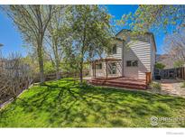 A spacious backyard features a wooden deck and mature trees, perfect for outdoor enjoyment at 1507 Begonia Way, Superior, CO 80027