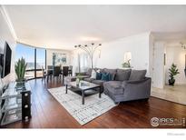 Spacious living room featuring a large sectional sofa, hardwood floors, and panoramic city views at 1625 Larimer St # 2601, Denver, CO 80202