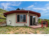 Unique octagonal home with a deck, red trim, and scenic views nestled into a hillside at 1629 Gold Run Rd, Boulder, CO 80302