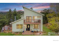 Inviting two-story home boasts a charming deck, lush greenery, and a picturesque mountain view at 473 Fred St, Boulder, CO 80302