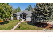 Charming single-story home featuring lush landscaping, a gray roof, and a welcoming front entrance at 5302 Pinehurst Dr, Boulder, CO 80301