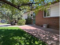 Charming brick home with a walkway, lush green lawn, and mature trees adding curb appeal at 700 33Rd St, Boulder, CO 80303
