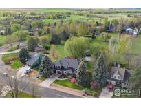 Stunning aerial view of a large home with mature trees, lush landscaping, and a sprawling green lawn at 7628 Estate Cir, Niwot, CO 80503