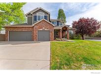 Charming two-story home with a well-manicured lawn, a brick facade, and a spacious three-car garage at 13042 Logan St, Thornton, CO 80241