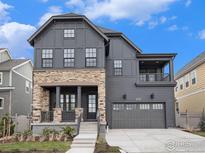 Charming two-story home features a stone-accented facade, balcony and an attached two-car garage at 1592 Ash Dr, Erie, CO 80516