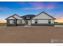 Charming exterior view of home featuring white siding, stone accents, and a welcoming front door at 16474 Essex S Rd, Platteville, CO 80651