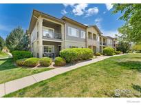 A well-manicured condo building featuring private patios, lush landscaping, and inviting walkways at 2239 Calais Dr # F, Longmont, CO 80504
