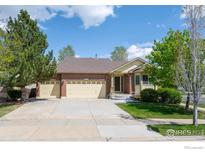 Charming brick home with three-car garage and well-maintained front yard and walkway at 2304 Dogwood Dr, Erie, CO 80516
