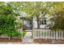 Charming home featuring a well-manicured front yard with a classic white picket fence and mature trees at 2552 Stonewall Ln, Lafayette, CO 80026