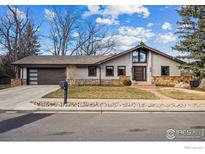 Beautiful single-story home with stone accents, a modern garage door, and a well-maintained front yard at 2575 Cragmoor Rd, Boulder, CO 80305