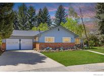 Charming single-story home with a well-manicured lawn, brick accents, and a two-car garage at 27 Cornell Dr, Longmont, CO 80503