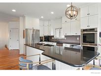 Spacious kitchen features stainless appliances, white cabinets, and granite countertops at 4212 E Orchard Pl, Centennial, CO 80121