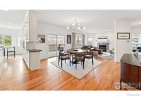 Bright, open-concept living and dining area featuring hardwood floors and modern lighting at 4212 E Orchard Pl, Centennial, CO 80121