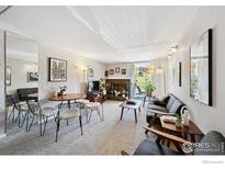 Cozy living room featuring a fireplace, a dining area, balcony, and a comfortable seating arrangement at 805 29Th St # 308, Boulder, CO 80303
