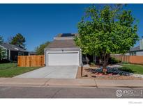 Charming two-story home featuring an attached two-car garage and solar panels, enhanced by a well-maintained lawn at 87 Macon Ct, Aurora, CO 80010