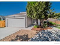 Charming home featuring a landscaped front yard, a garage, and a welcoming entrance at 87 Macon Ct, Aurora, CO 80010