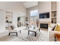 Bright living room with vaulted ceilings, large windows, fireplace, and modern furnishings at 87 Macon Ct, Aurora, CO 80010