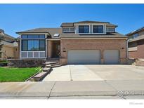 Beautiful brick two-story home featuring a two-car garage and professionally landscaped front yard at 1105 Oakhurst Dr, Broomfield, CO 80020