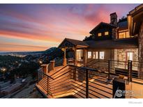 Spacious exterior deck showcases scenic mountain views and a luxurious home design at sunset at 166 Valley View Way, Boulder, CO 80304