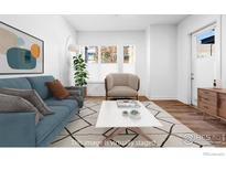 Bright living room features a blue sofa, neutral accent chair, white coffee table and a decorative rug at 1707 Walnut St # 102, Boulder, CO 80302