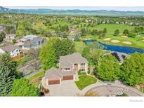 Stunning aerial view of home on a golf course with mature trees and mountain views at 2222 Tamarron Ln, Lafayette, CO 80026