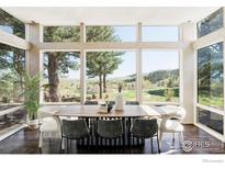 Bright dining room features large windows with scenic views and a stylish wood table with seating for eight at 2848 S Lakeridge Trl, Boulder, CO 80302