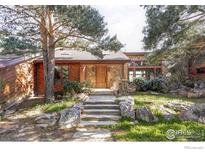 Charming home with a stone and wood facade, complemented by a stone stairway and natural landscaping at 2848 S Lakeridge Trl, Boulder, CO 80302