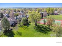 Beautiful home featuring a lush green lawn with mature trees and a neighborhood tennis court at 4059 Nevis St, Boulder, CO 80301