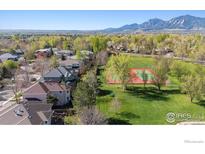 Serene aerial view of the property showcasing its lush surroundings, nearby tennis court, and mountain views at 4059 Nevis St, Boulder, CO 80301