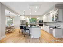 Modern kitchen with white cabinetry, stainless steel appliances, and a granite countertop island at 4059 Nevis St, Boulder, CO 80301