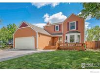 Inviting two-story home featuring a charming front porch and well-maintained lawn at 536 W Sycamore Cir, Louisville, CO 80027