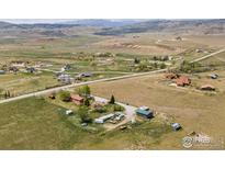 Expansive aerial view of the property showcasing its rural setting and mountain views in the distance at 6310 W County Road 4, Berthoud, CO 80513